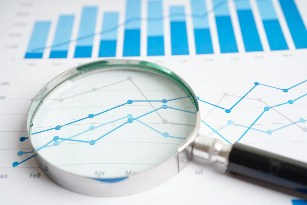 Magnifying glass on charts graphs paper. Financial development,
